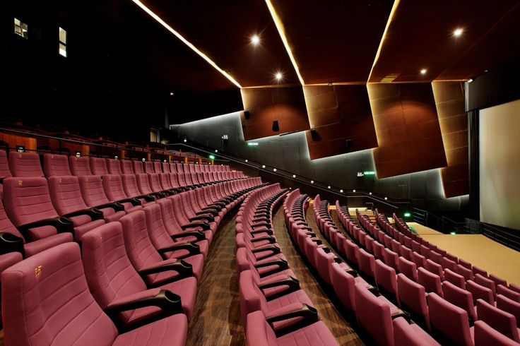 Theater chairs in red velvet fabric installed on a well-lit venue