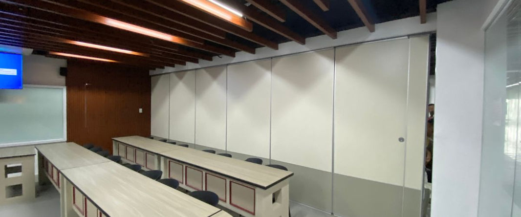 A white, operable wall system divides the room, offering flexible space configurations