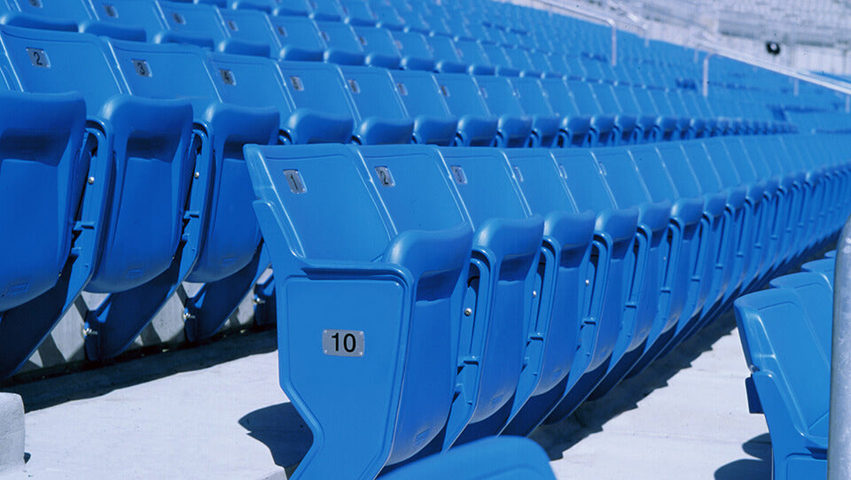 blue bleacher chairs in huge venue on a sunny day